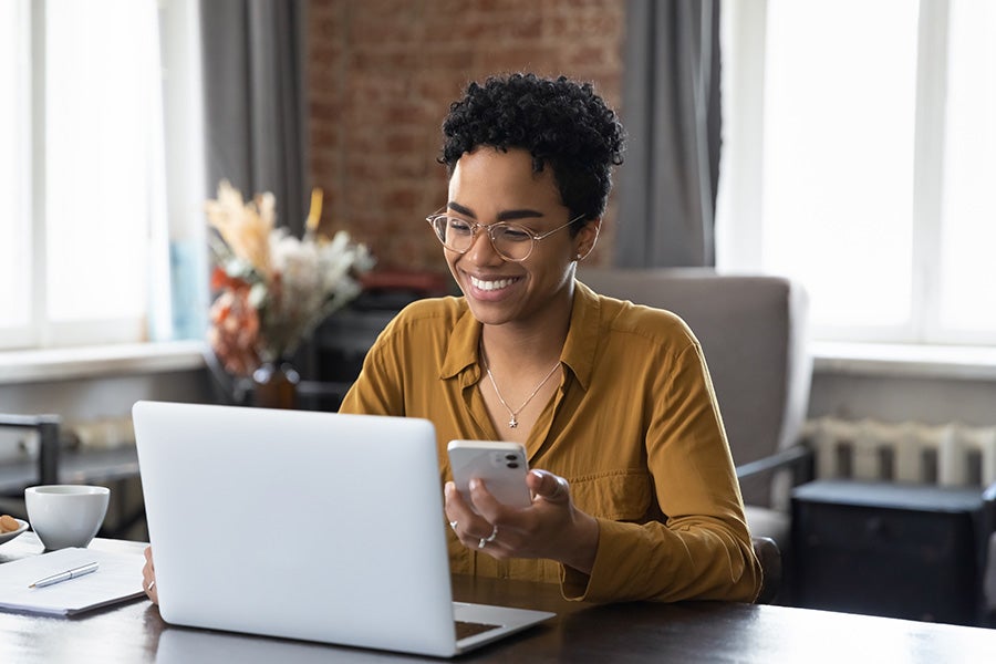 Happy woman looking at laptop.